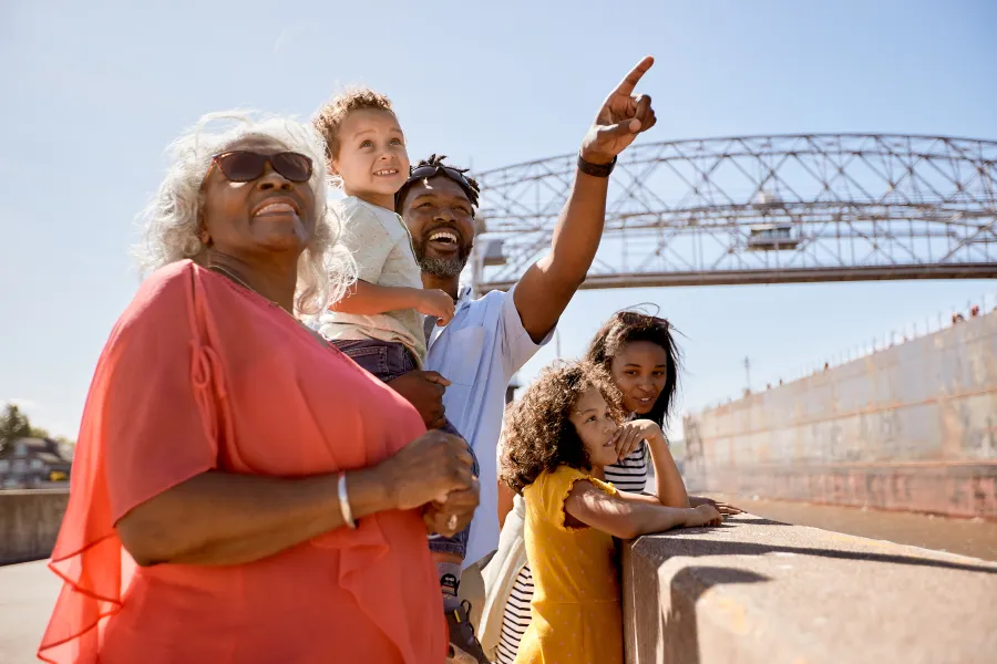 Family on the Canal Park pier in Duluth, pointing toward something in the distance