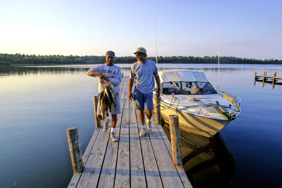 Lake of the Woods holding stringer of fish on dock Hennum's Oak Island Resort