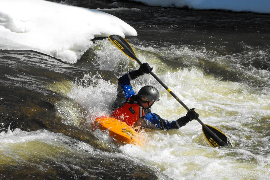 A kayaker takes advantage of the winter white caps as he navigates down the river