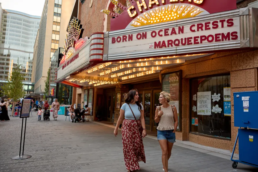 A couple friends walk by the Historic Chateau Theatre 