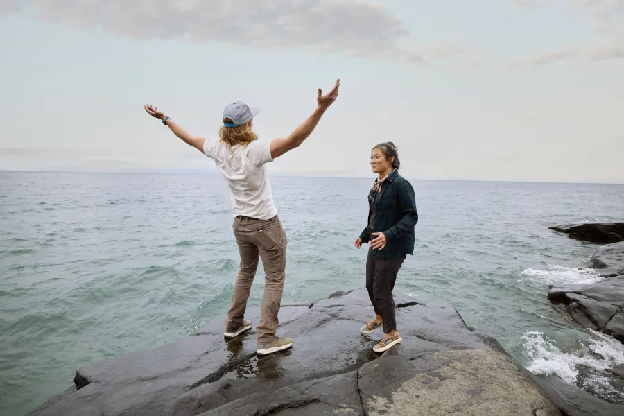 Two people standing on the rocky shores of Lake Superior 
