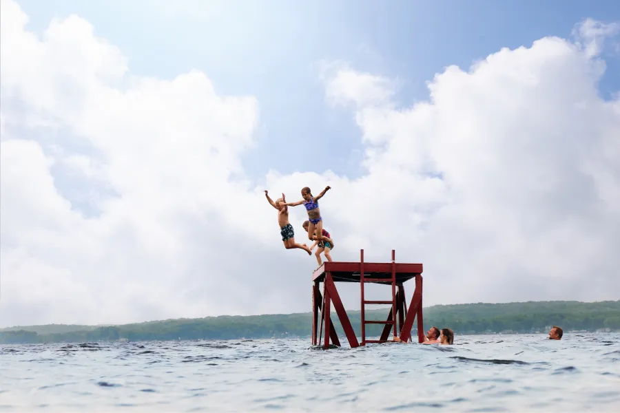 A family goes swimming in the lake at Fair Hills Resort 