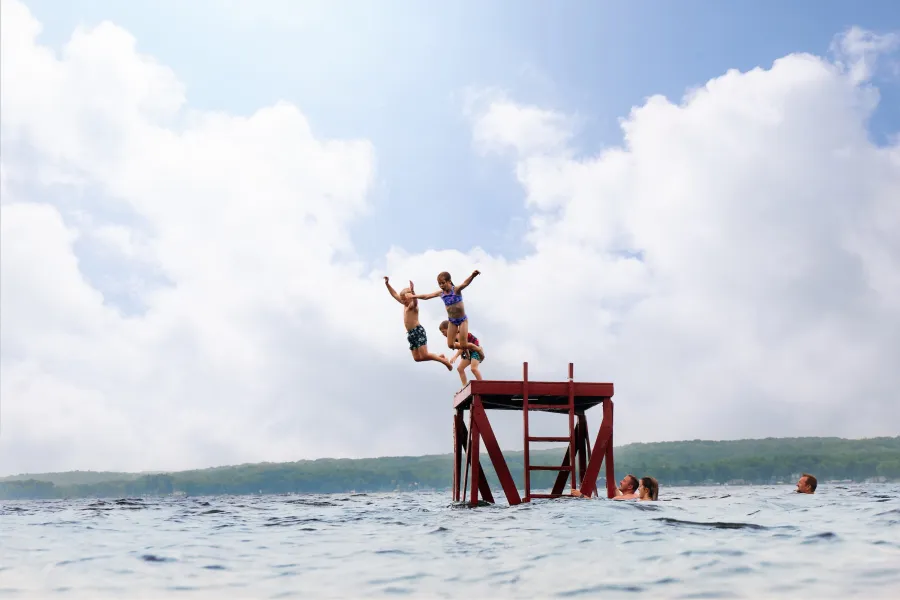 A family goes swimming in the lake at Fair Hills Resort 