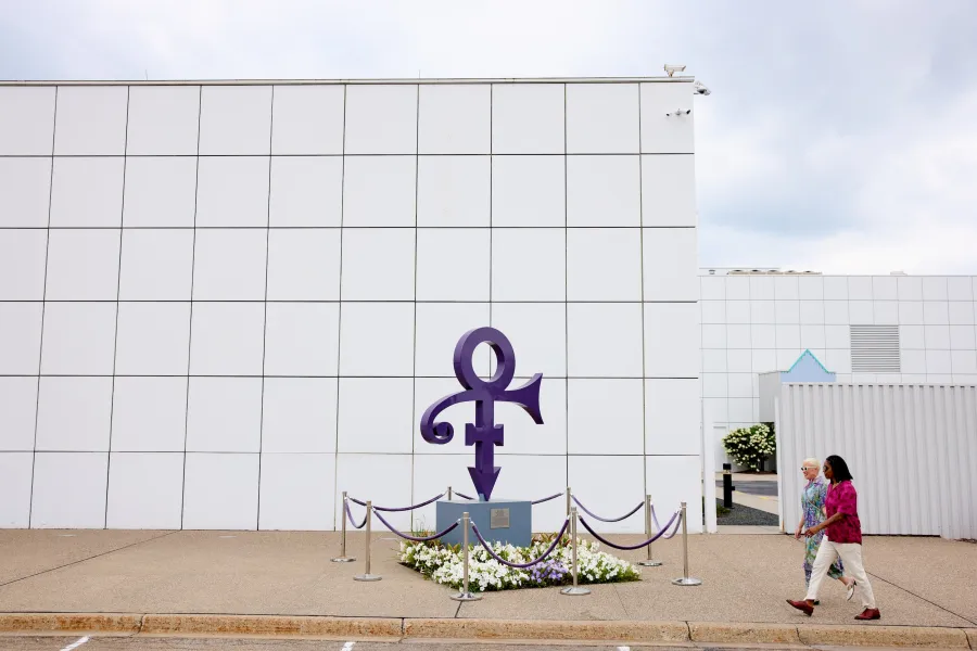 A couple walks in front of Paisley Park