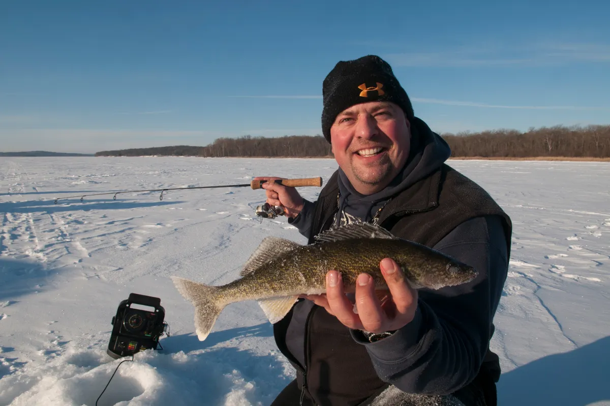 Man catching a fish while ice fishing on Leech Lake
