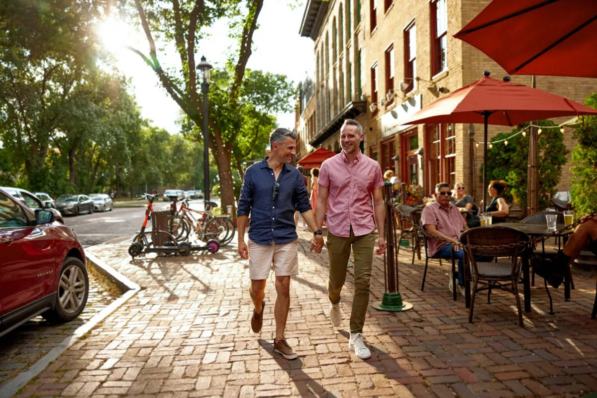 A couple walks past Aster Cafe's patio