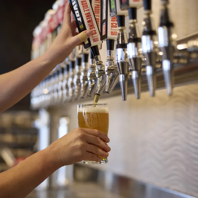 A bartender pours a pint at Bent Paddle