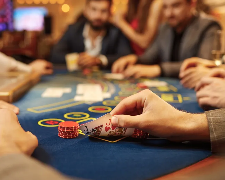 Man peeks at a pair of jacks while playing poker at a casino