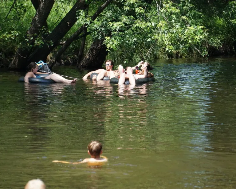 A group of friends relaxes while river tubing on the Platte River