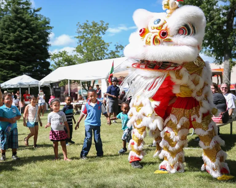 A group of kids watching a Chinese lion dance at the Worthington International Festival