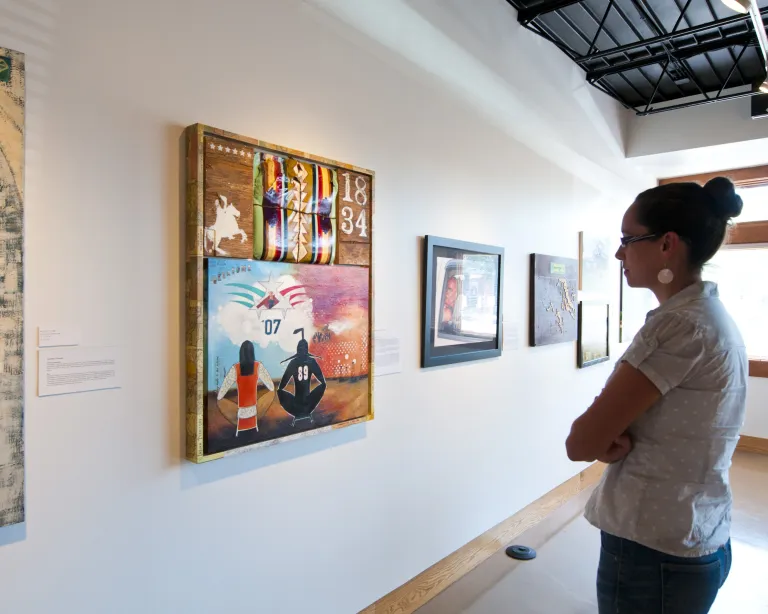 Woman looking at an exhibit at All My Relations Gallery
